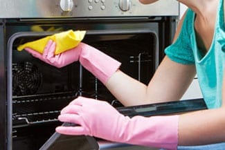 woman cleaning an oven